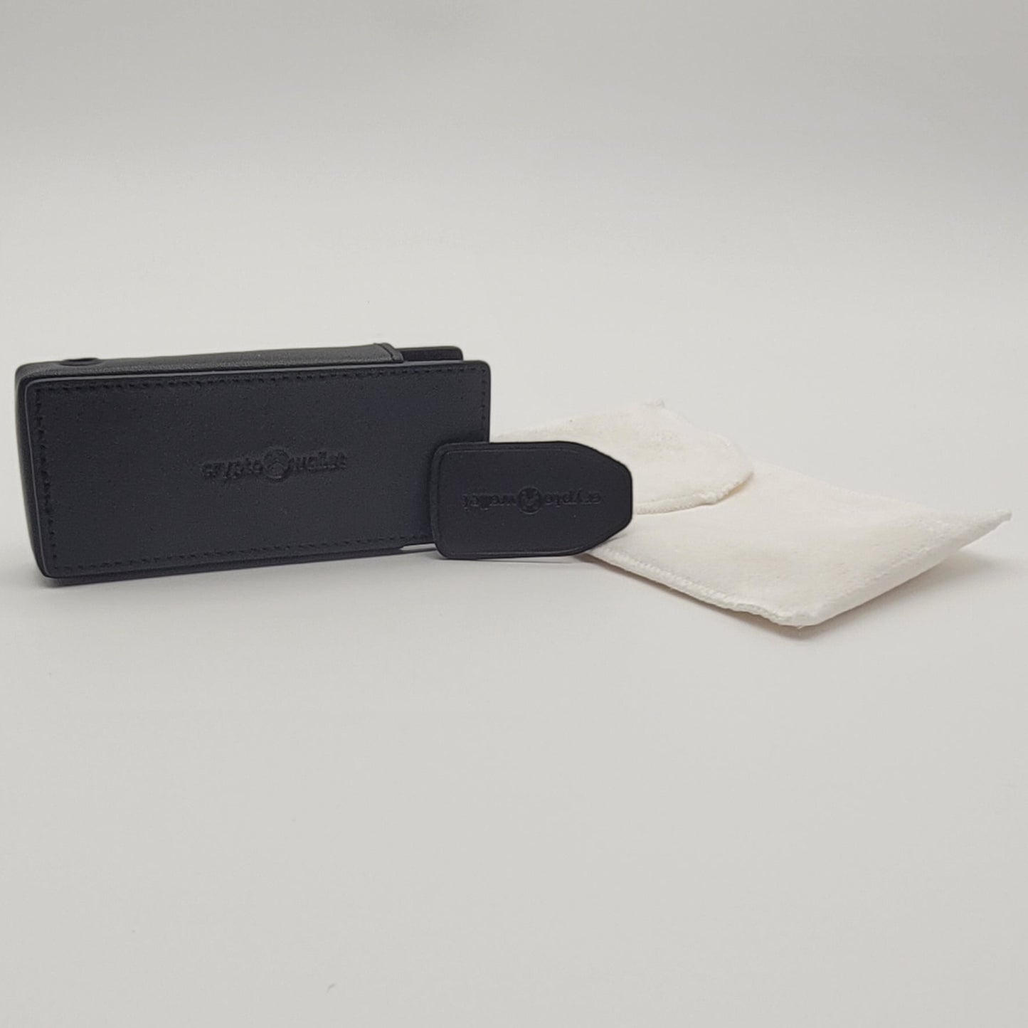 Black leather wallet and cleaning cloth on a light gray background